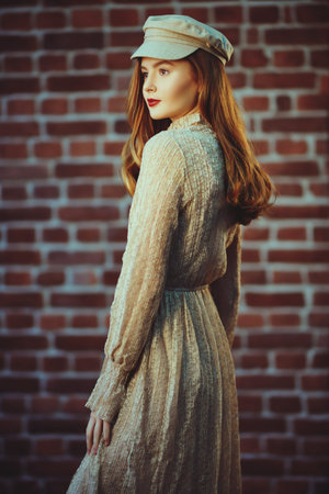 Pretty young girl with natural make-up and in a light beige dress looks out the window and smiles...