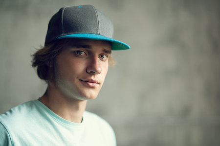 A close up portrait of a young goodlooking man in a cap posing indoor. Casual men fashion, beauty,...