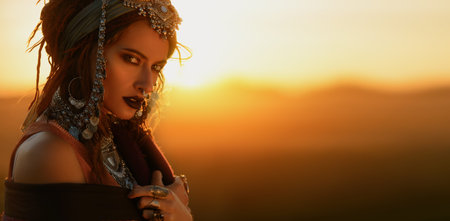 Beautiful fashion model posing in boho style clothes in the rays of the sunset. Outdoor fashion.の写真素材