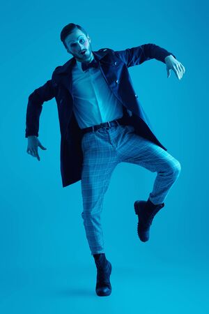 Art and fashion. Male mime artist. A young man with makeup in the style of the 20s poses in an elegant suit with expression. Full length portrait.の写真素材