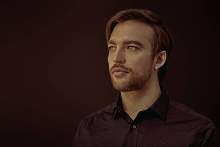 Portrait of a handsome man in classic dark blue shirt on a black background. Business style, businessman. Studio shot. Copy space.の写真素材