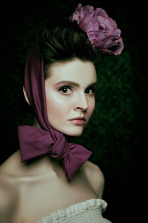 Elegant fashion model with a floral headdress. Fashion, clothing style, accessories. Studio portrait.の写真素材