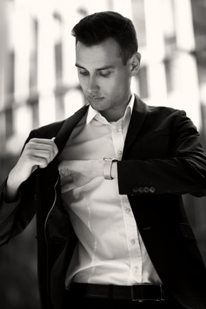 A portrait of a goodlooking young guy checking the inside pocket of his jacket. Men's beauty,...