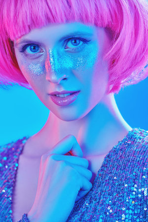 Beauty, makeup and cosmetics concept. Portrait of an attractive girl with shiny glitter freckles and...