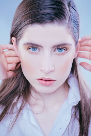 A close up portrait of a beautiful dark-haired young woman posing over the white background. Beauty, cosmetics.の写真素材