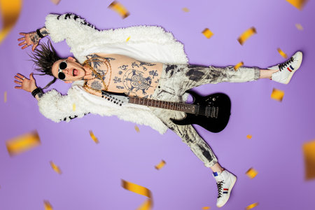 A full length portrait of a cool young punk man posing in the studio. Casual punk fashion, beauty.