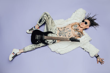 A full length portrait of a cool young punk man posing in the studio. Casual punk fashion, beauty.