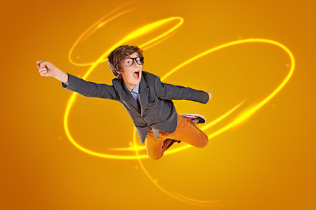 Educational concept. Funny smart boy teenager student flies through the air like a superhero. Yellow...
