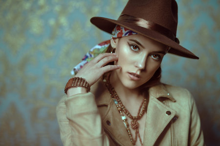 Modern bohemian style. Portrait of a beautiful young woman with elegant natural make-up, beads and...