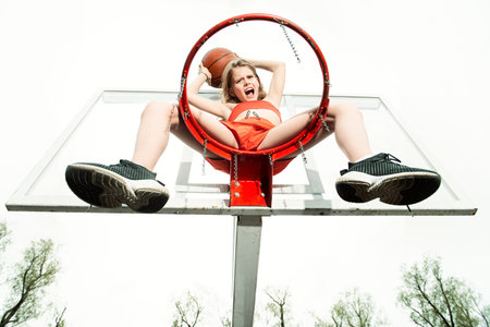 A full length portrait of a sporty teenager girl posing on the basketball pinch. Sport fashion,...