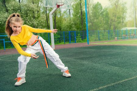 A full length portrait of a teenager girl posing on the sports ground. Sport fashion, active lifestyle.の写真素材
