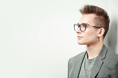 Portrait of a smart young man in a suit and glasses. Studio shot. Men's beauty.の写真素材