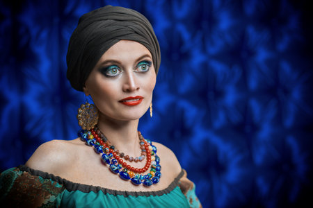 Portrait of a beautiful gypsy woman on a dark blue background. National gypsy costume, ethnic....
