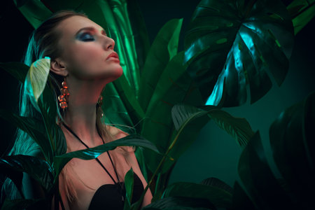 Beautiful sultry woman with wet hair stands among tropical plants. Beauty, fashion and cosmetics...