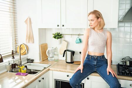 COVID-19. Staying at home and social distancing. Beautiful young girl stays at home.の写真素材