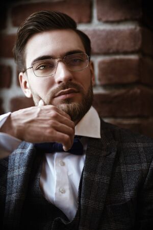 Portrait of a handsome gentleman with a beard and mustache wearing elegant suit and spectacles. Men's beauty, fashion. Businessman portrait. Optics for men.の写真素材