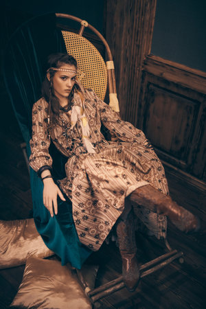 Bohemian lifestyle. Stunning young woman with hair, make-up and dress in boho style posing in a...