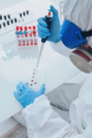COVID-19. Doctor, microbiologist, scientist in a protective suit, makes a study of coronavirus in...