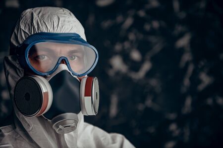 Coronavirus or COVID-19 concept. Portrait of a doctor in a protective PPE suit, glasses and respiratory mask on the background of a coronavirus spreading around the world. Copy space.の写真素材