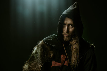 Portrait of a medieval pilgrim in old historical clothes over black background. Historical...
