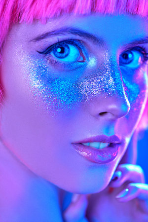 Beauty, makeup and cosmetics concept. Portrait of an attractive girl with shiny glitter freckles and...