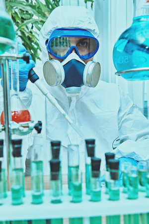 COVID-19 and medicine. A doctor, microbiologist, scientist in a protective suit, makes a research in...