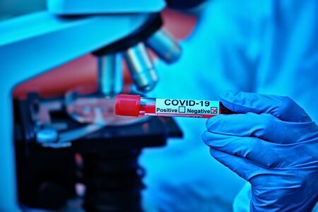 COVID-19. Doctor, microbiologist, scientist in a protective suit, makes a research on blood samples of infected people in the laboratory. Coronavirus test.の写真素材