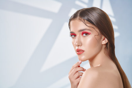 Make-up and cosmetics concept. Portrait of a beautiful girl with shiny make-up and red arrows on her...