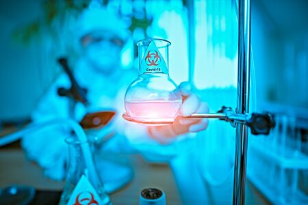 COVID-19 and medicine. Laboratory study of coronavirus. Scientist in a protective suit, makes a study of coronavirus in the laboratory.Innovative technologies in medicine.の写真素材