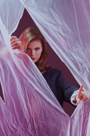 Art beauty fashion portrait of a gorgeous young woman posing with polyethylene. Beauty, make-up and cosmetics.の写真素材