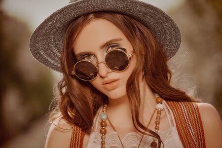 Outdoor portrait of a pretty modern hipster hippie girl. Spirit of freedom and adventures.の写真素材