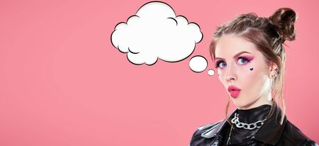 Portrait of a modern e-girl with bright pink make-up posing on a pink background. Studio shot. Copy space.の写真素材