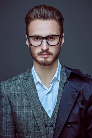 Elegant handsome man in spectacles and fashionable suit. Business style. Studio portrait.の写真素材