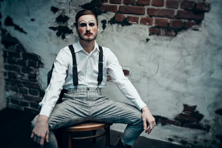 Art, history and fashion. A young man with makeup in the style of the 20s poses in an elegant suit...