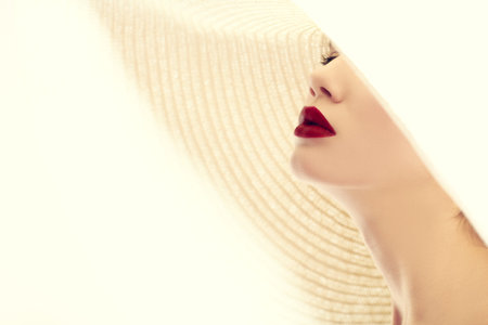 Close up portrait of a gorgeous young woman in elegant summer wide-brimmed hat. Fashion shot, beauty.の写真素材