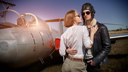 Handsome man pilot hugs his beautiful girlfriend before the flight. Aviation and love.の写真素材