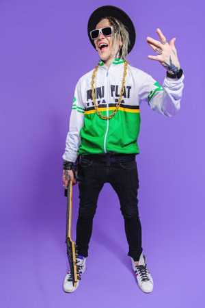 A full length portrait of a cool young guitarist in the studio. Casual punk fashion, music.