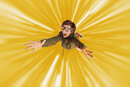 Emotional funny smart boy teenager student flies through the air like a superman and screams....