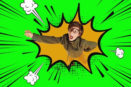 Educational concept. Funny smart boy teenager student flies through the air like a super man. Colorful yellow and green background.の写真素材
