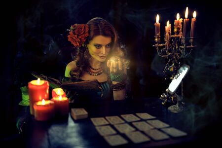 Magnificent fortune teller woman reading future on magical crystal ball and tarot cards.の写真素材