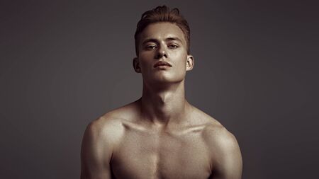 Portrait of a handsome athletic young man with perfect muscular body. Sports and bodybuilding. Men's beauty and health.の写真素材