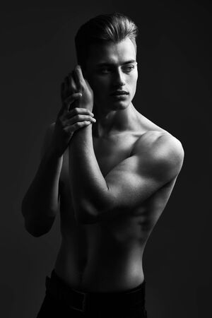 Black-and-white portrait of a handsome athletic young man with perfect muscular body. Sports and bodybuilding. Men's beauty and health.の写真素材