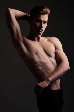 Portrait of a handsome athletic young man with perfect muscular body. Sports and bodybuilding. Men's beauty and health.の写真素材