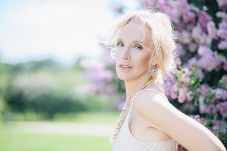 A portrait of an elderly stylish woman in the summer park. Beauty, fashion.の写真素材