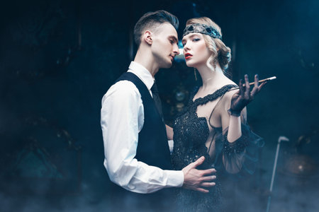 Handsome man and beautiful young woman in the style of the 1920s. Fashion clothes, make-up and hair...