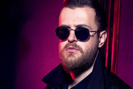 A portrait of a stylish man wearing sunglasses. Beauty and style for men.の写真素材