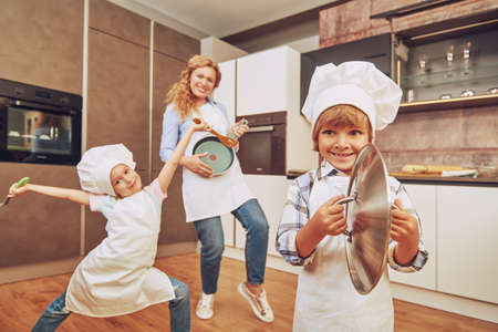 Happy family in a kitchen at home. Mother and her children having fun together in the kitchen.の写真素材