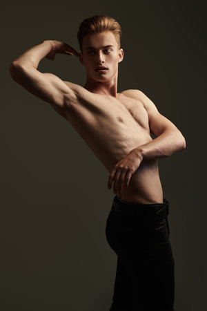 Portrait of a handsome athletic young man with perfect muscular body. Sports and bodybuilding. Men's beauty and health.の写真素材