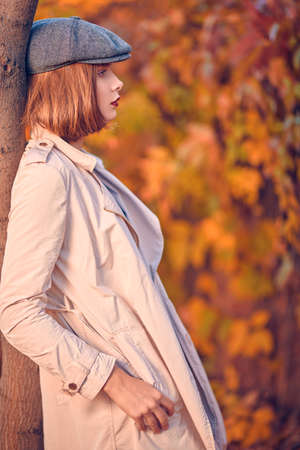 Pretty modern girl in casual clothes walks through the autumn city park. Seasonal style, autumn beauty, fashion.の写真素材