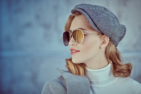Romantic young woman with natural makeup and beautiful wavy blonde hair wearing autumn clothes and...